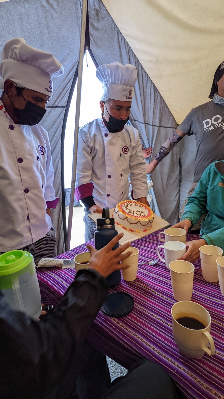 Scène sous une tente avec des gens qui célèbrent avec un gâteau de session.