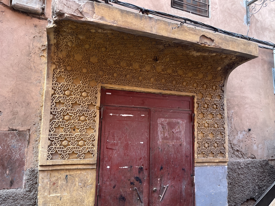 Ornate door set in a decorated facade with geometric patterns.