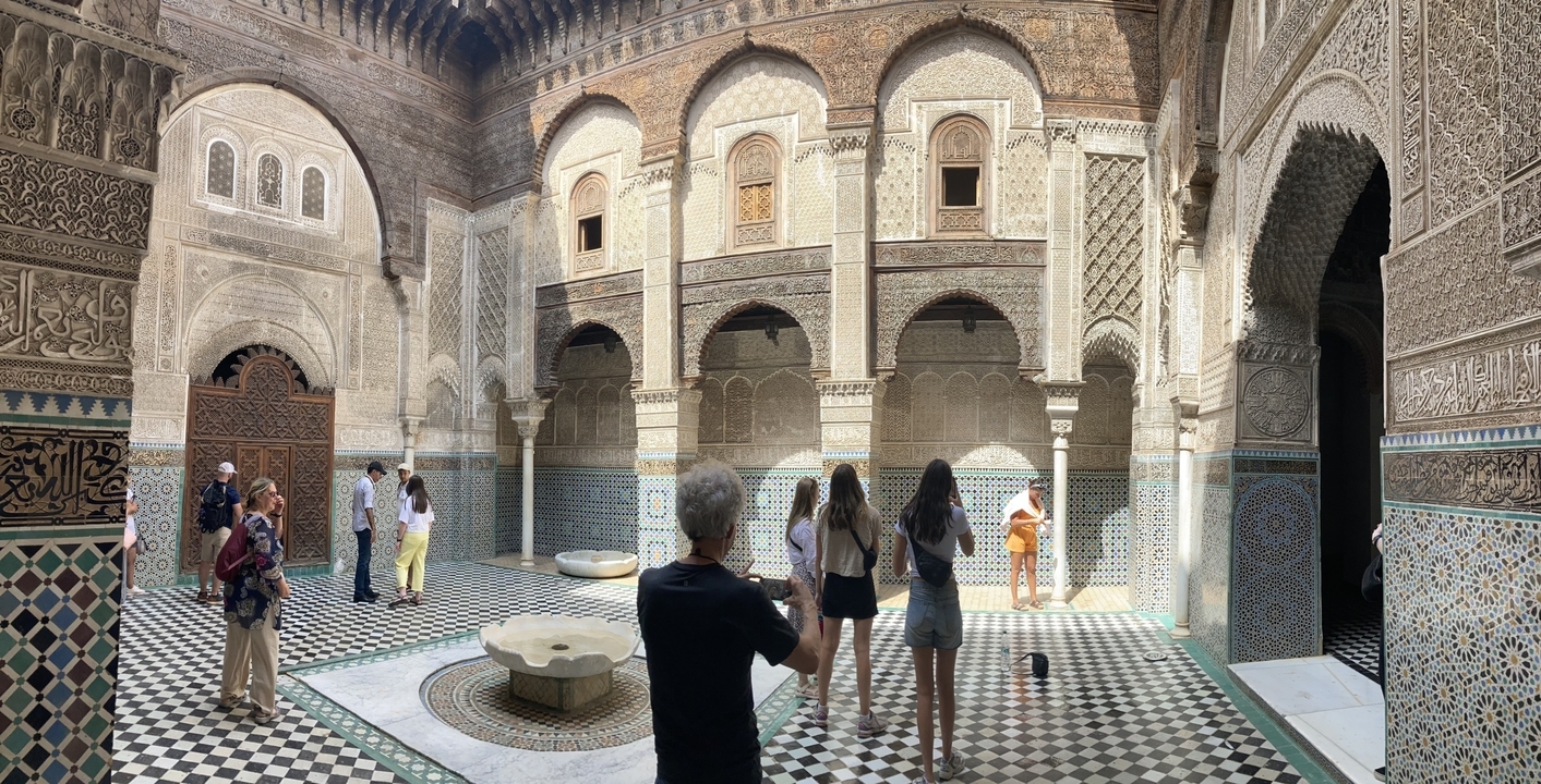 People visiting a historical building with intricate tiles.