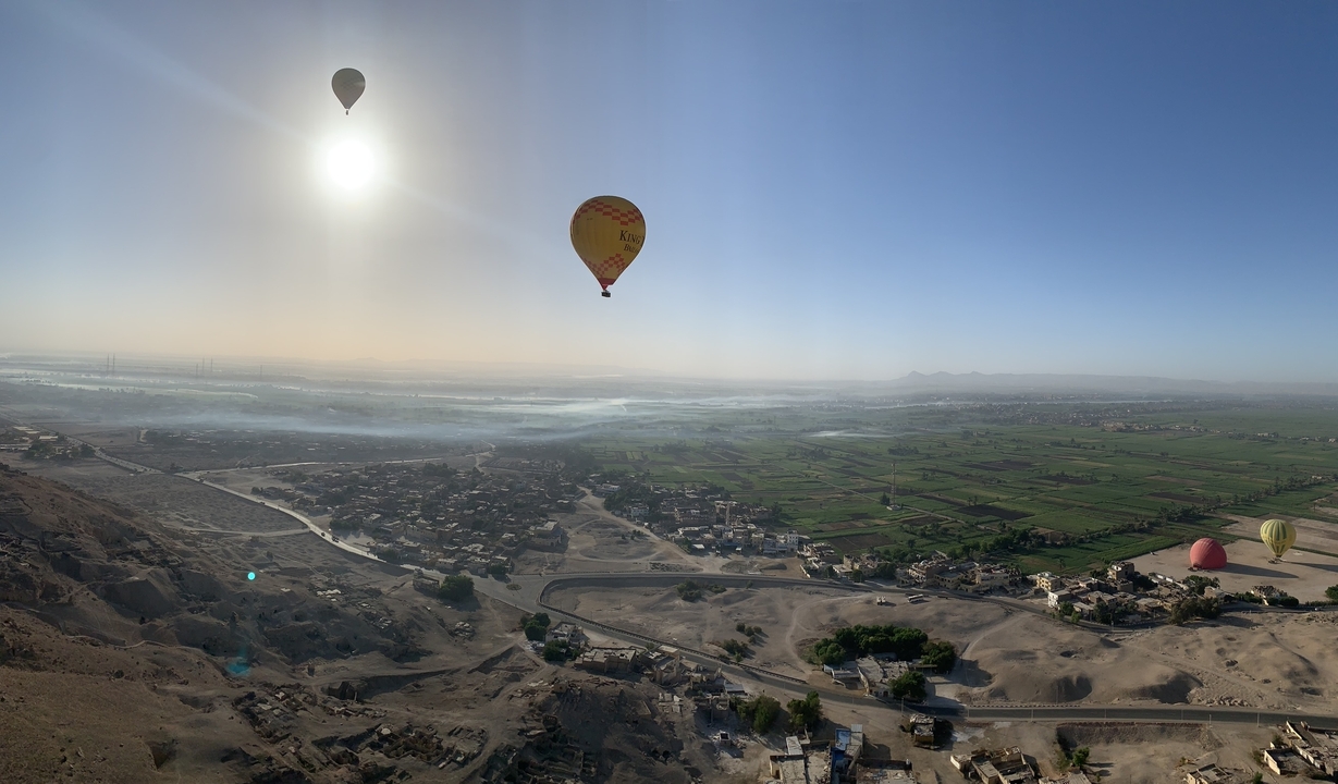 Landscape with hot air balloons during sunrise.