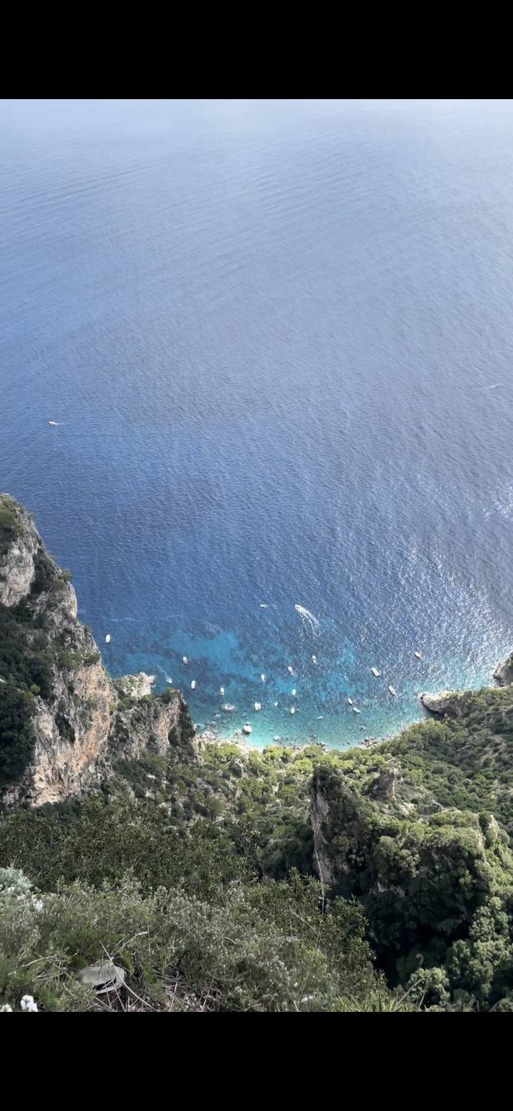 Vue aérienne d'une mer bleu clair avec des bateaux visibles.