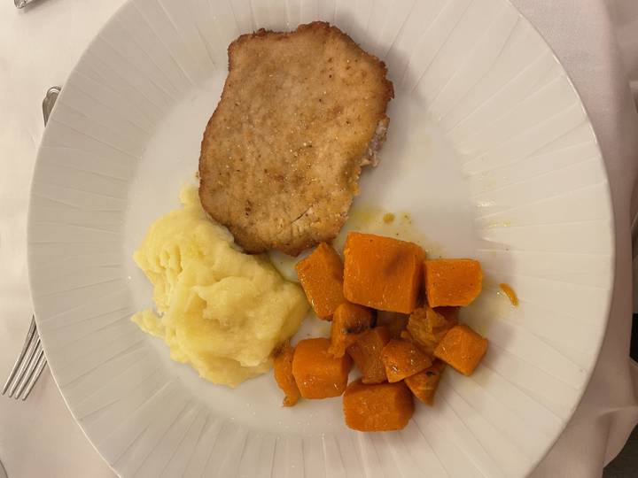 Assiette de nourriture composée de purée de pommes de terre, de légumes cuits et de viande.