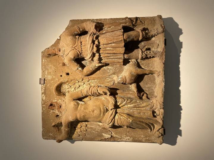 Sculpture ancienne en pierre représentant des personnages historiques.