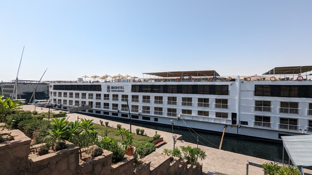 Modern cruise ship docked at the riverside.