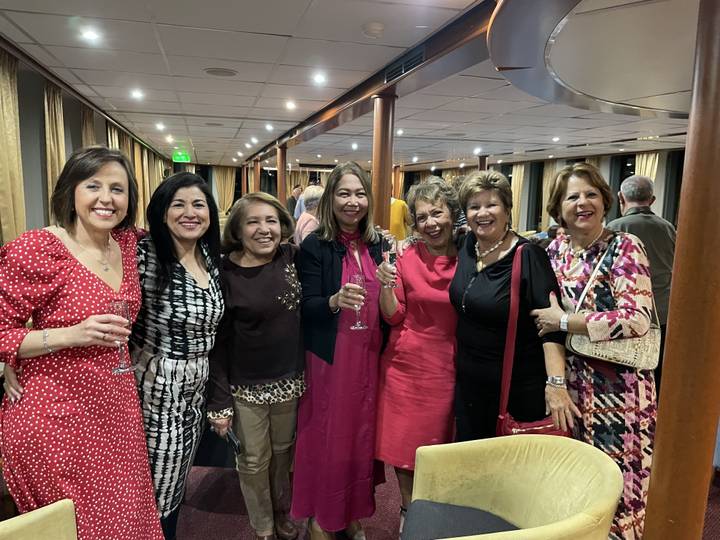 Groupe de femmes prenant la pose sur une croisière avec des boissons