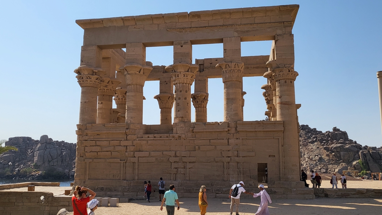 Temple ruins with columns and visitors around.