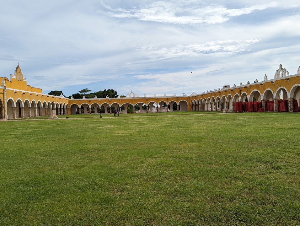Colonnade around an open grassy courtyard.