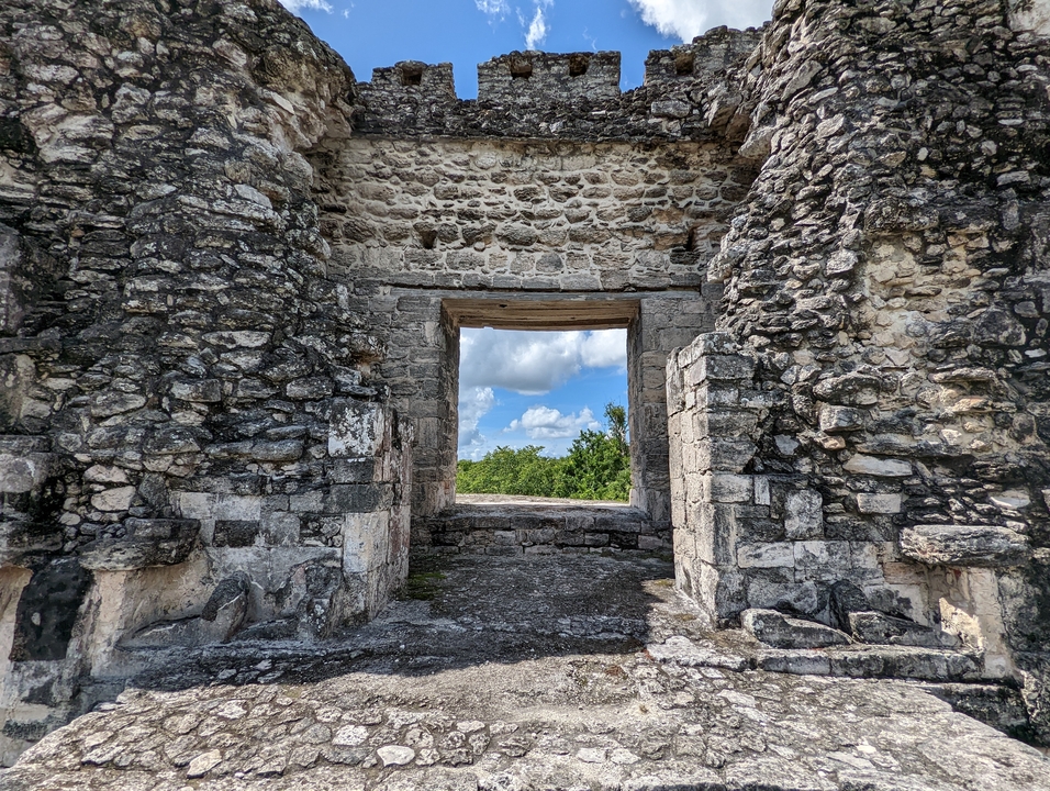 Stone ruins forming a window overlooking greenery.
