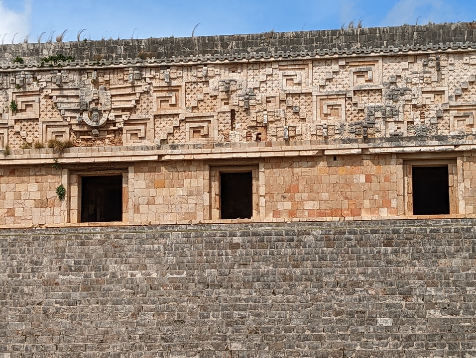 Ancient Mayan structure with intricate stone carvings.