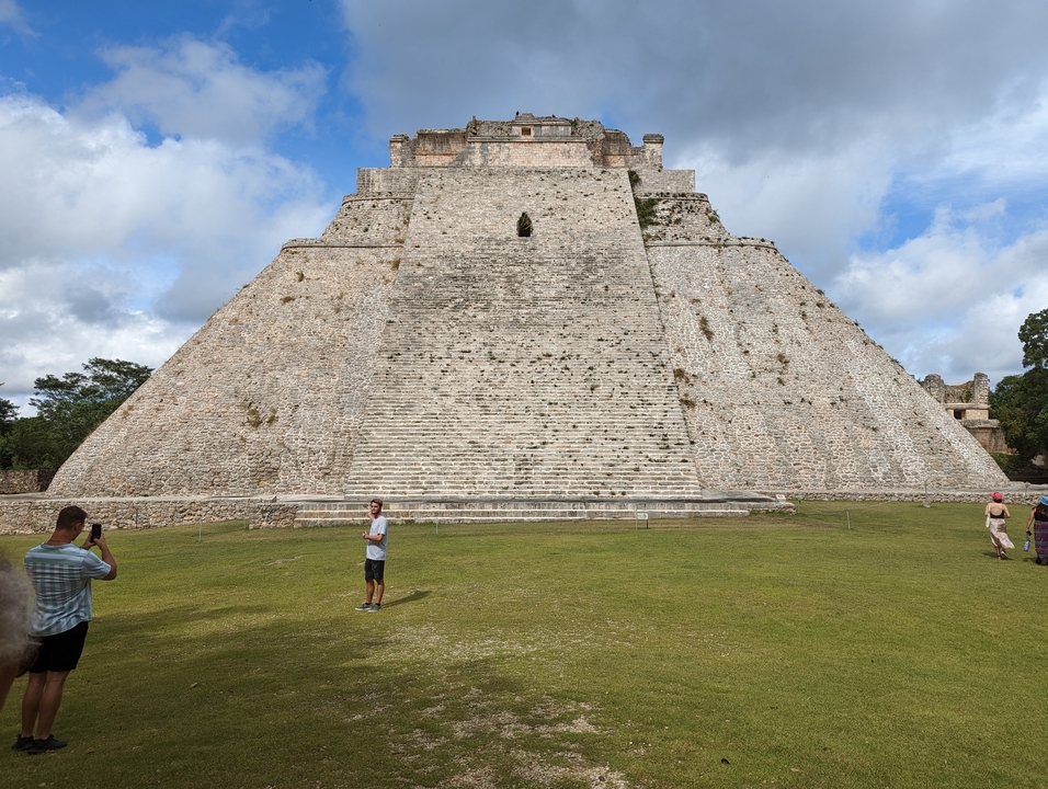 Large pyramid structure with a few visitors around.