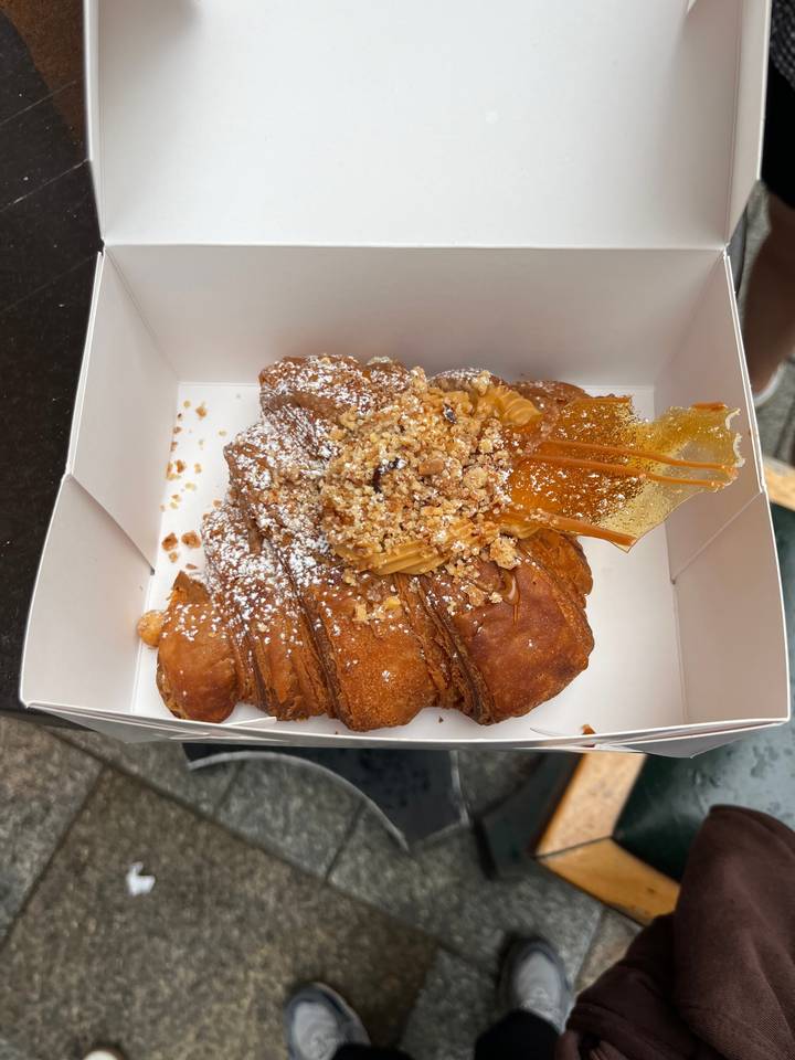 Close-up of a croissant with toppings in a box.
