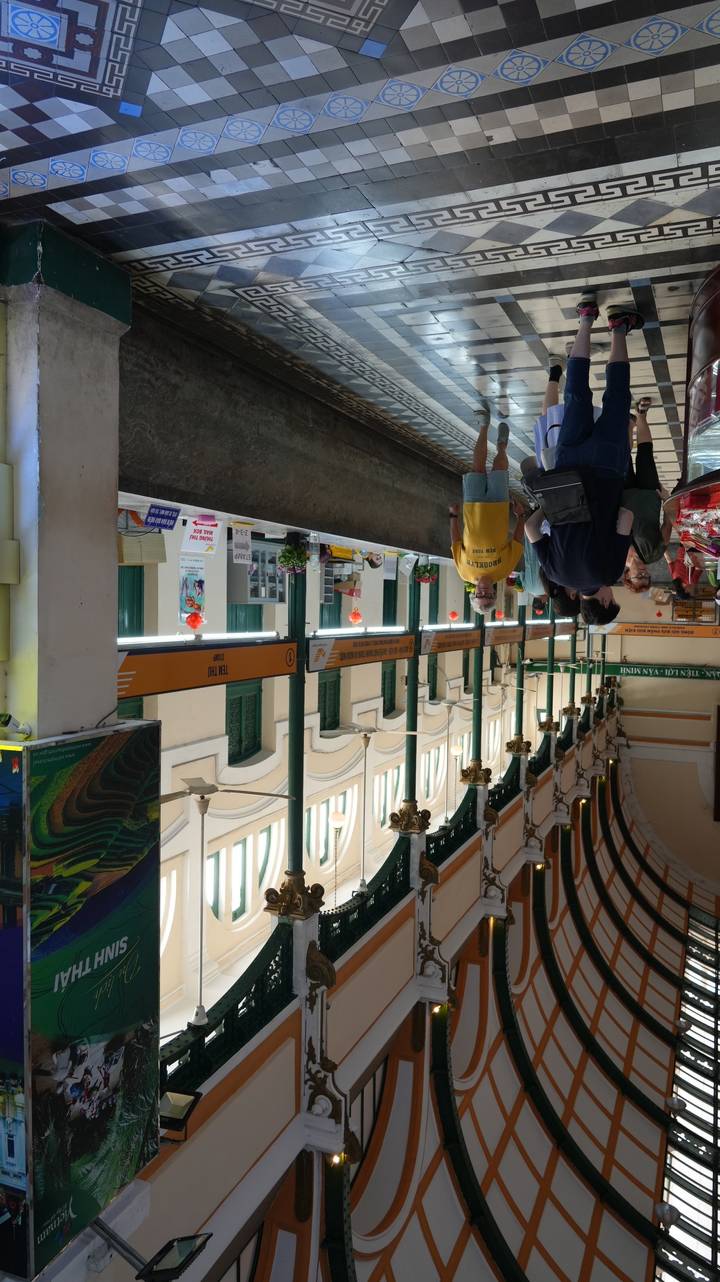 Interior of a hallway with architectural details and people walking.