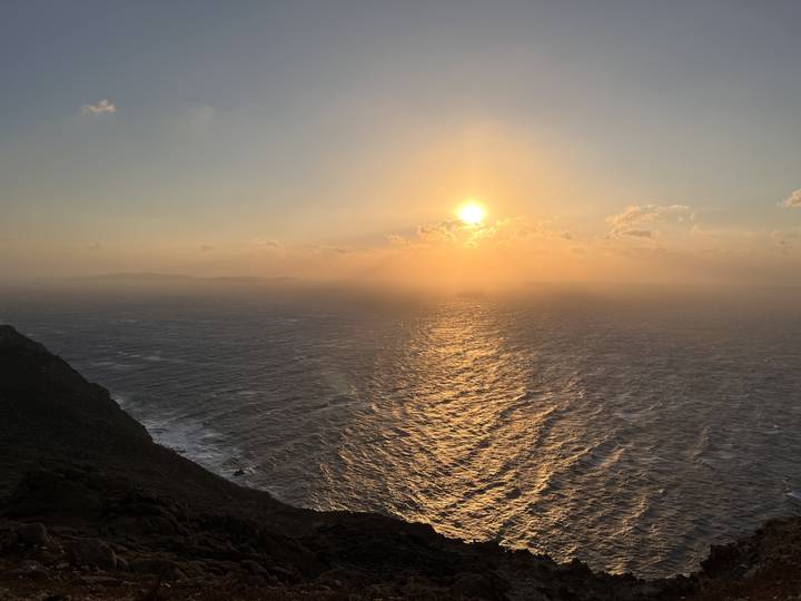 Sunset over the ocean from a cliffside view.
