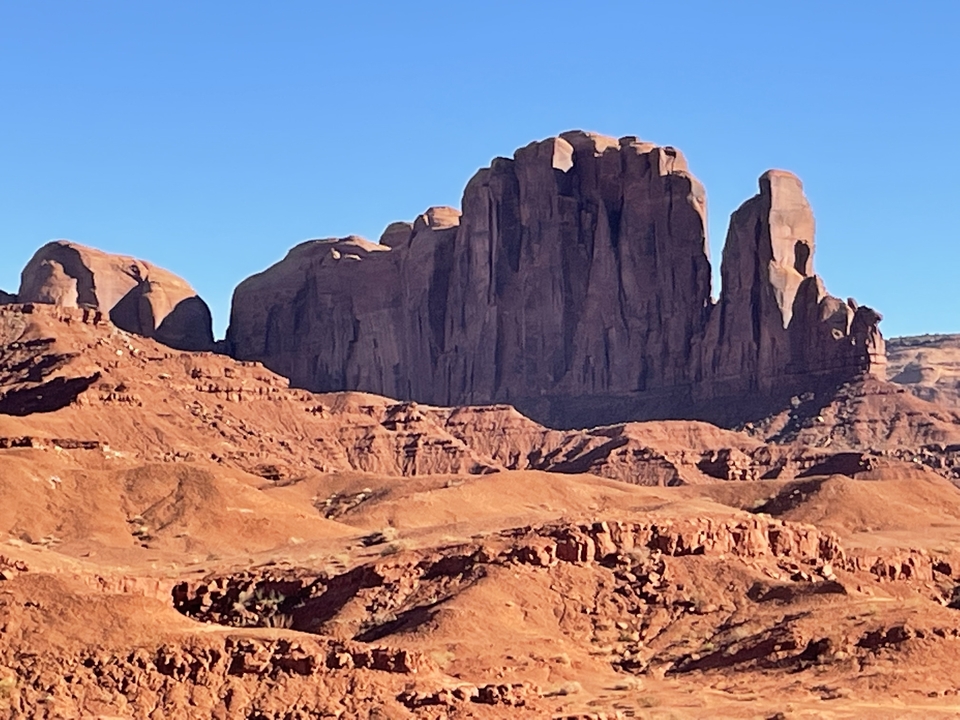 Sandstone buttes in Monument Valley under a bright blue sky.