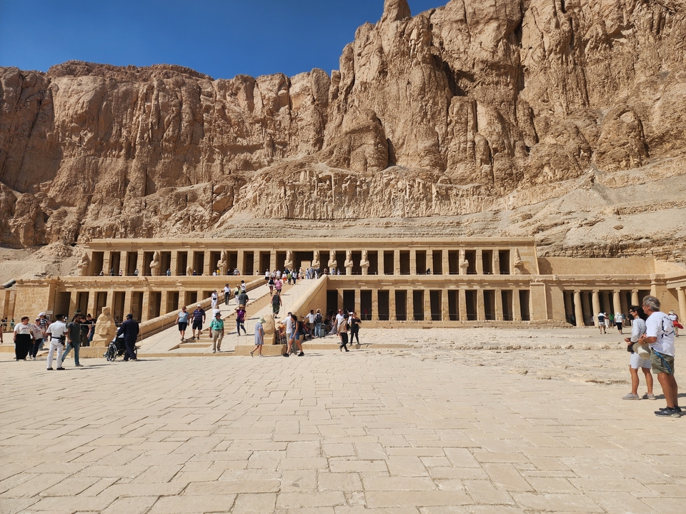 Large temple with tourists walking towards it.