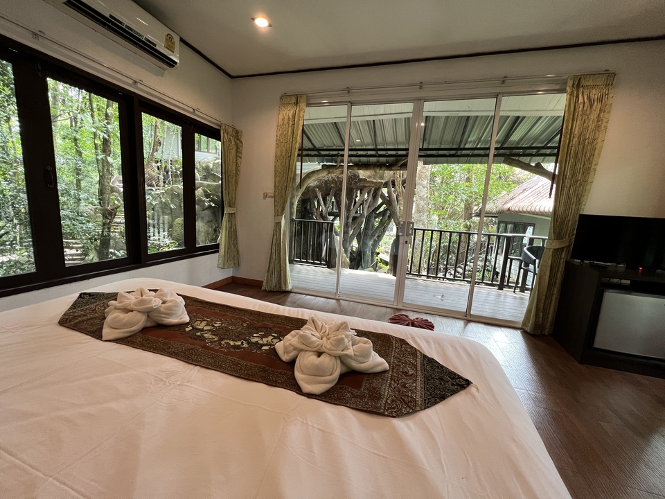 Cozy hotel room with a view of trees through the window.