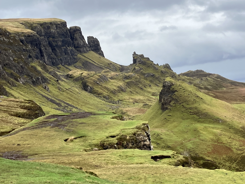 Rugged green landscape with rocky cliffs.