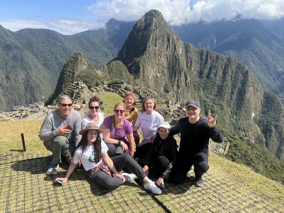 Group of people posing with Machu Picchu in the background.