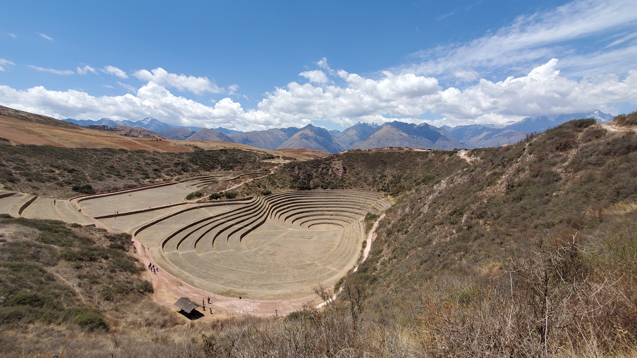 Circular terraces in a valley with mountains in the background.