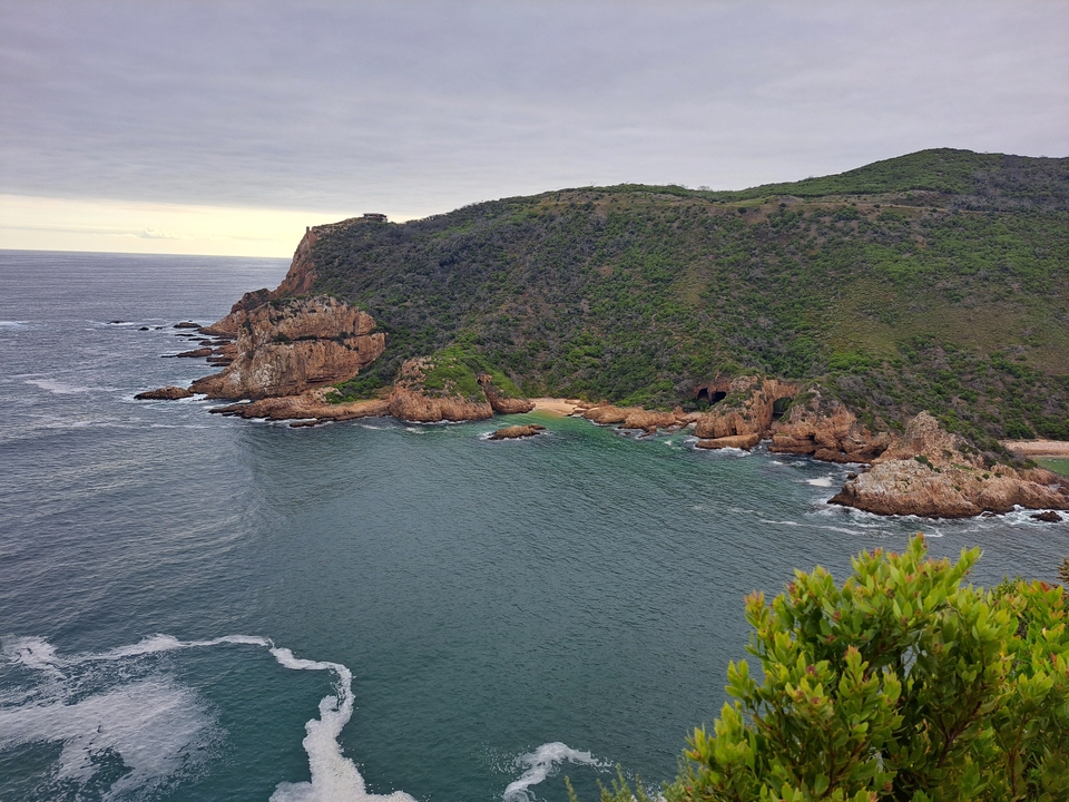 Coastal cliffs with lush greenery and ocean view.