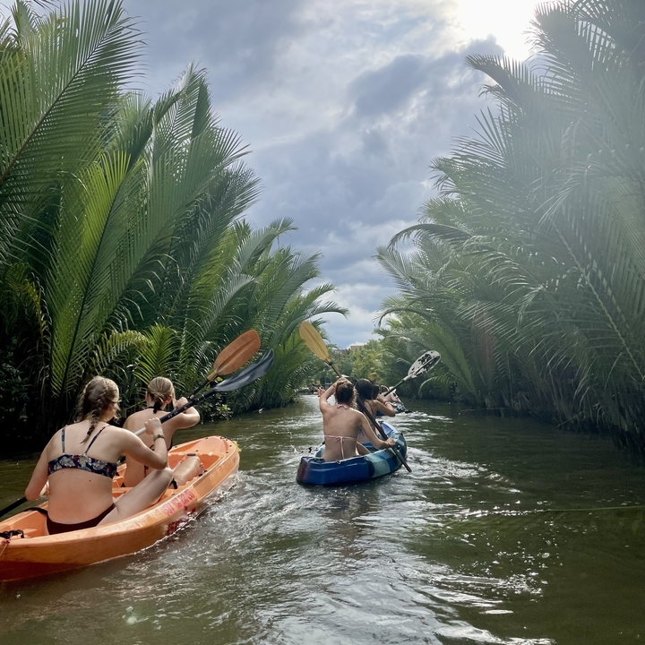 People kayaking in a lush river