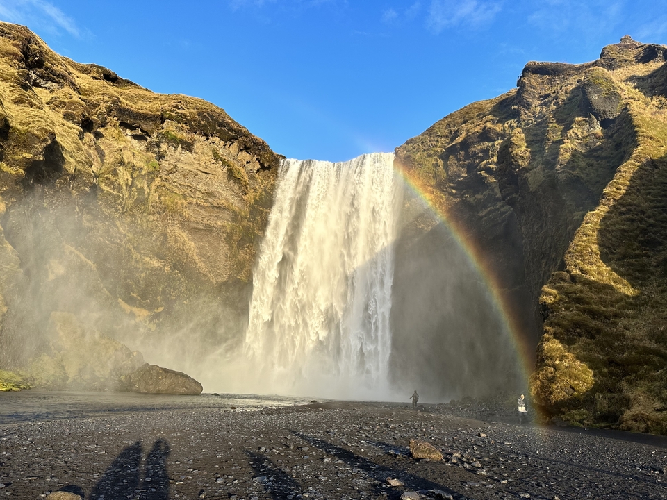 Waterfall with a rainbow in a rocky landscape.