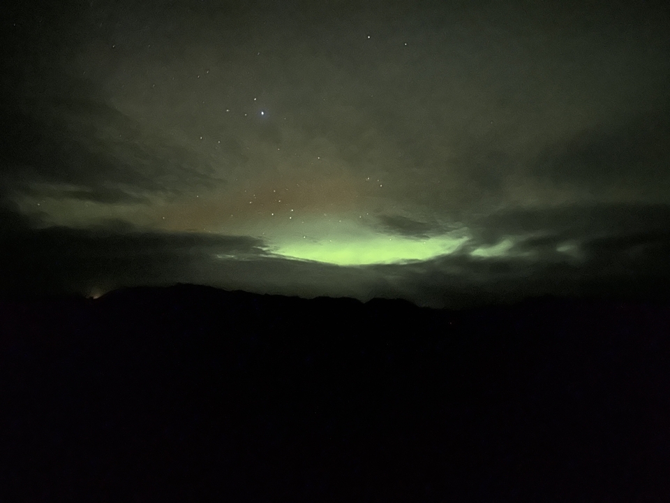 Dimly lit sky with faint aurora borealis.