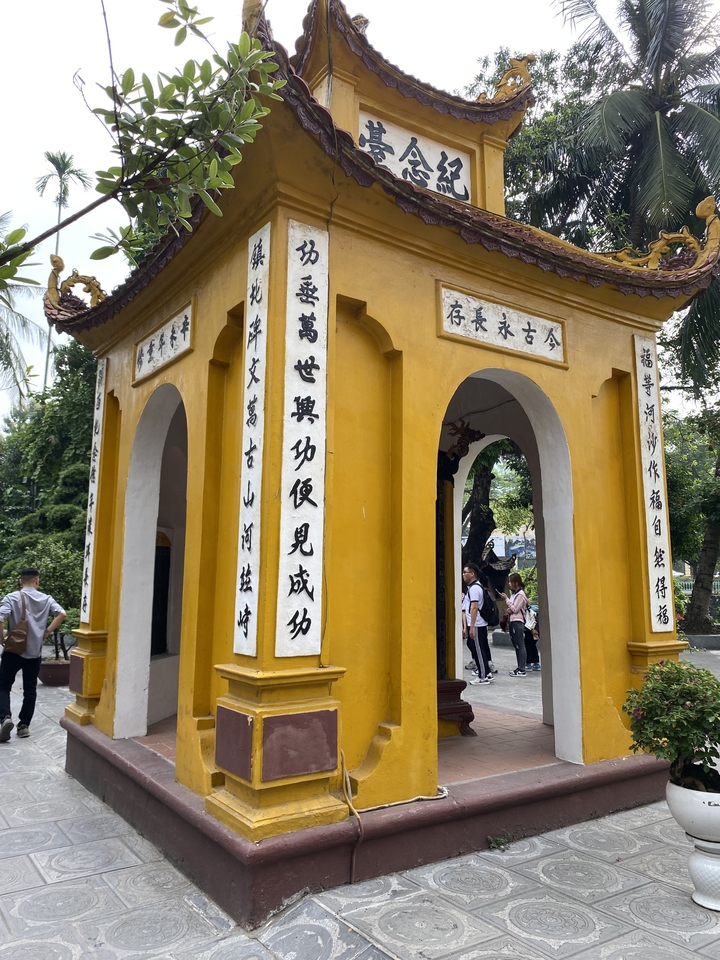 Small temple with Vietnamese script and people nearby.