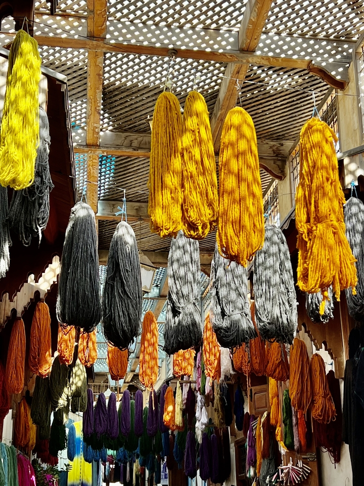 Hanging strands of dyed yarns.