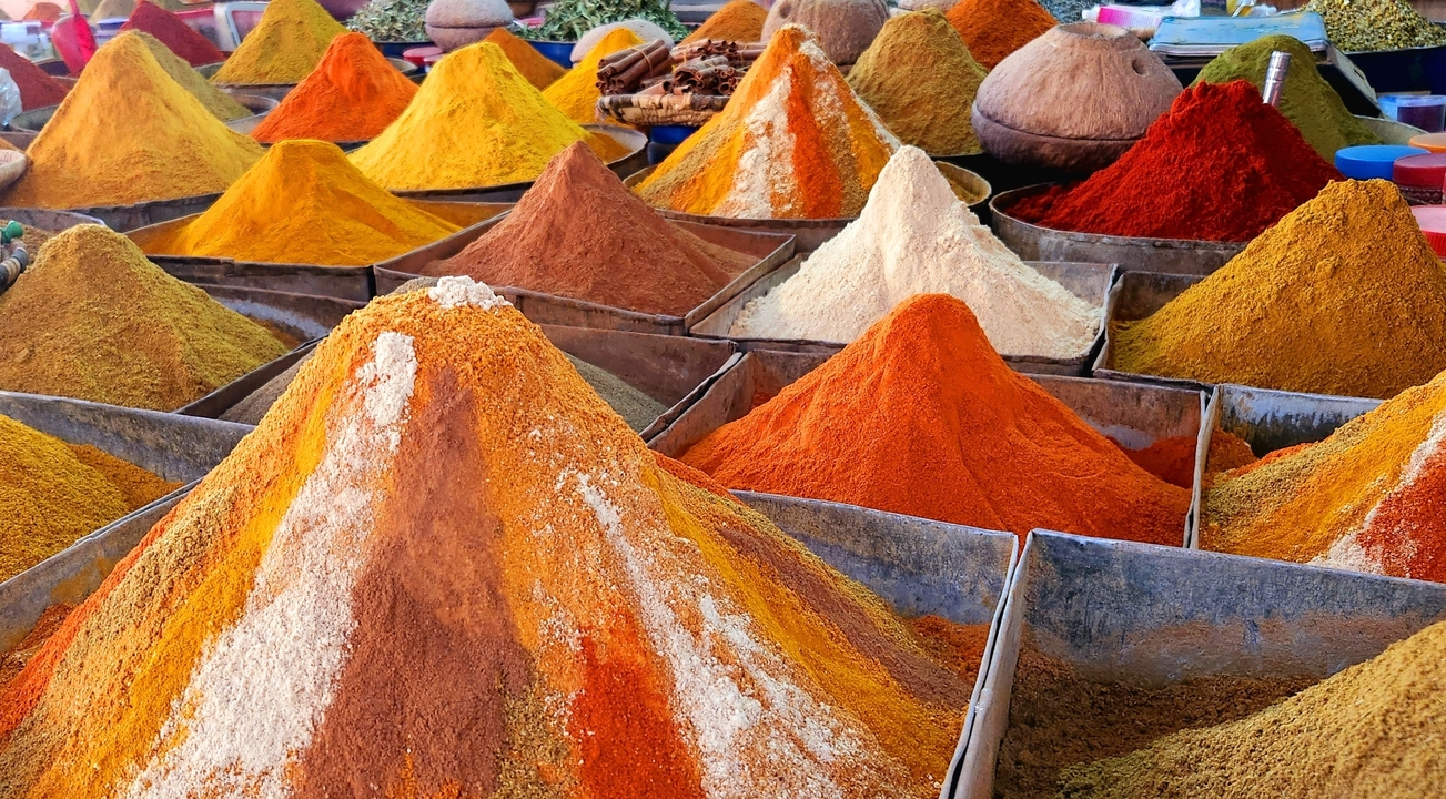 Vibrant piles of colorful spices in a market setting.