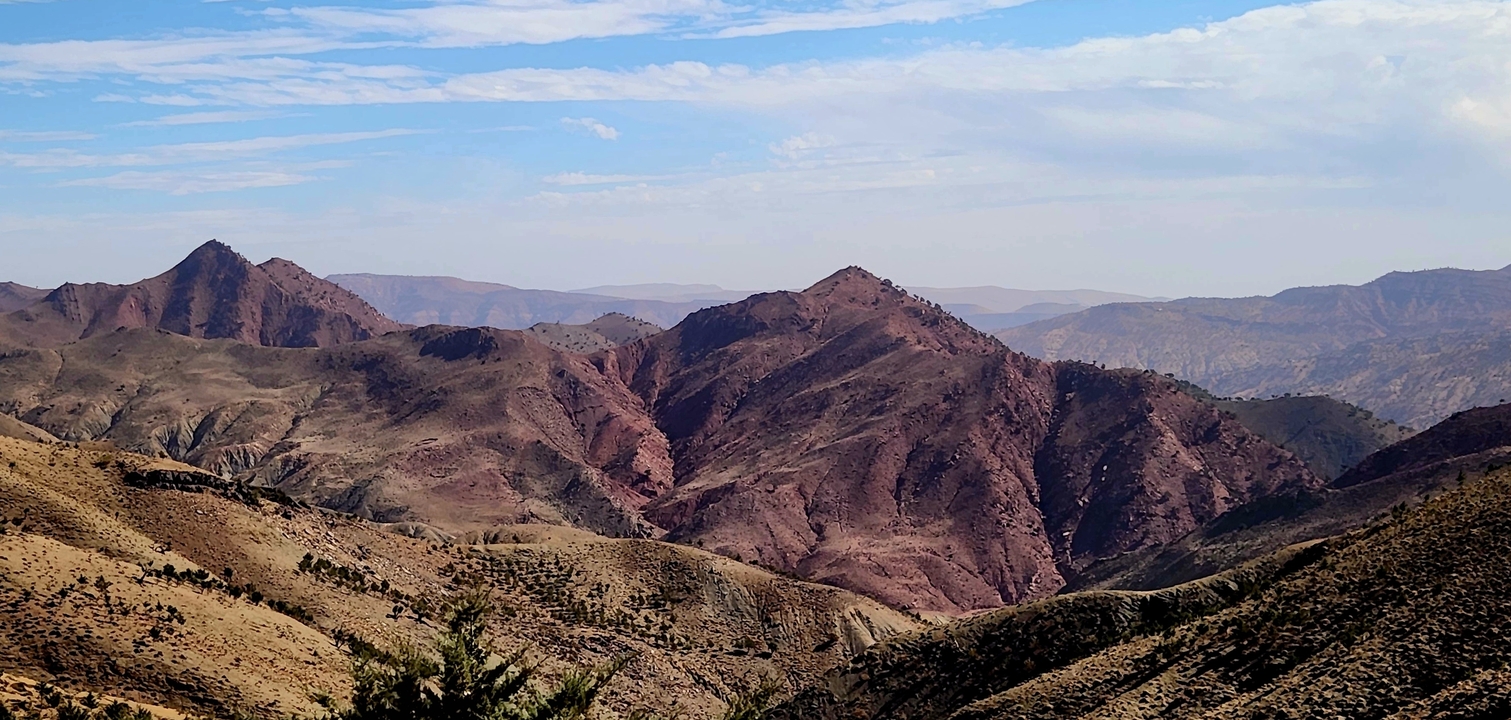 Panoramic view of rugged desert mountains under a clear sky.