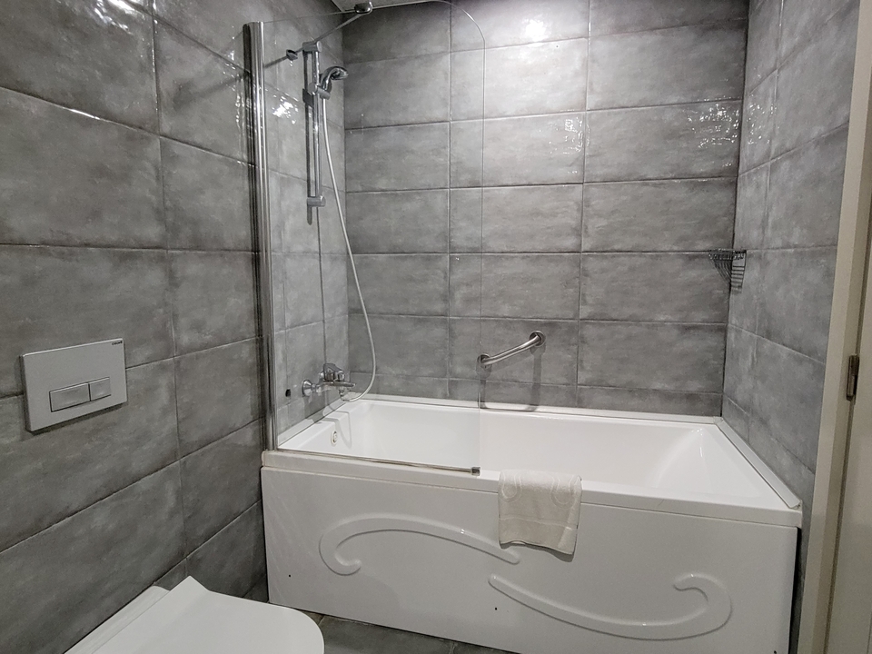 Bathroom interior with bathtub and tiled walls.