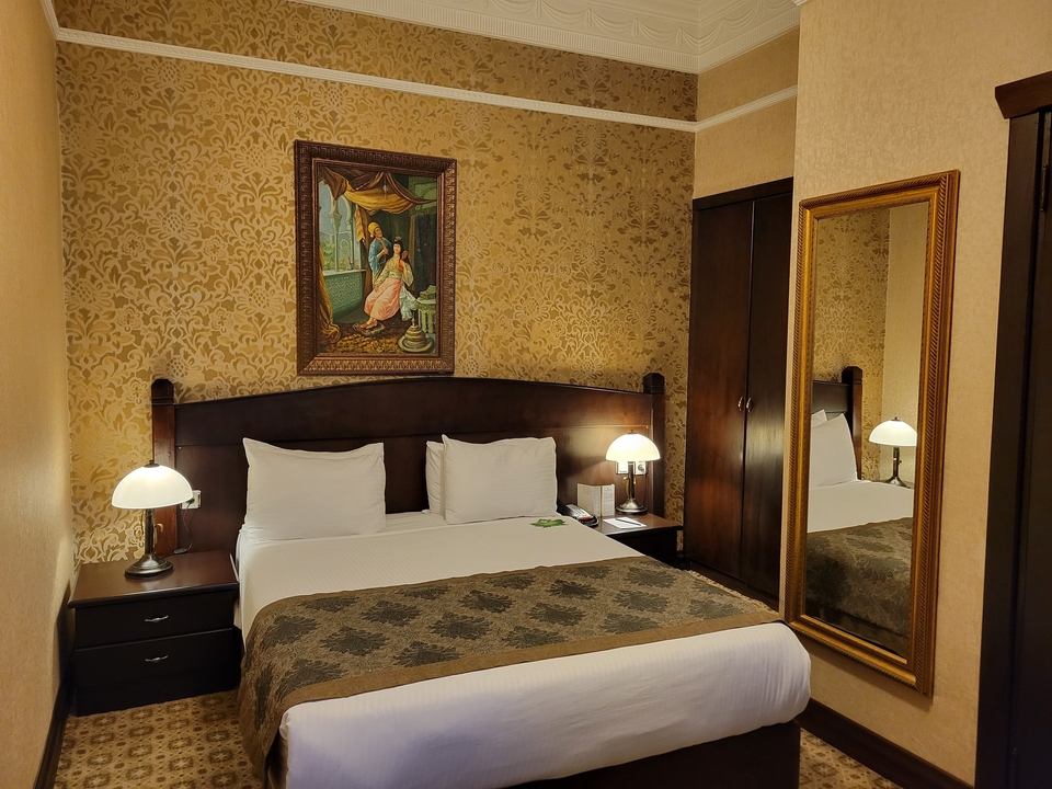 Hotel room with classic decor and a large bed.