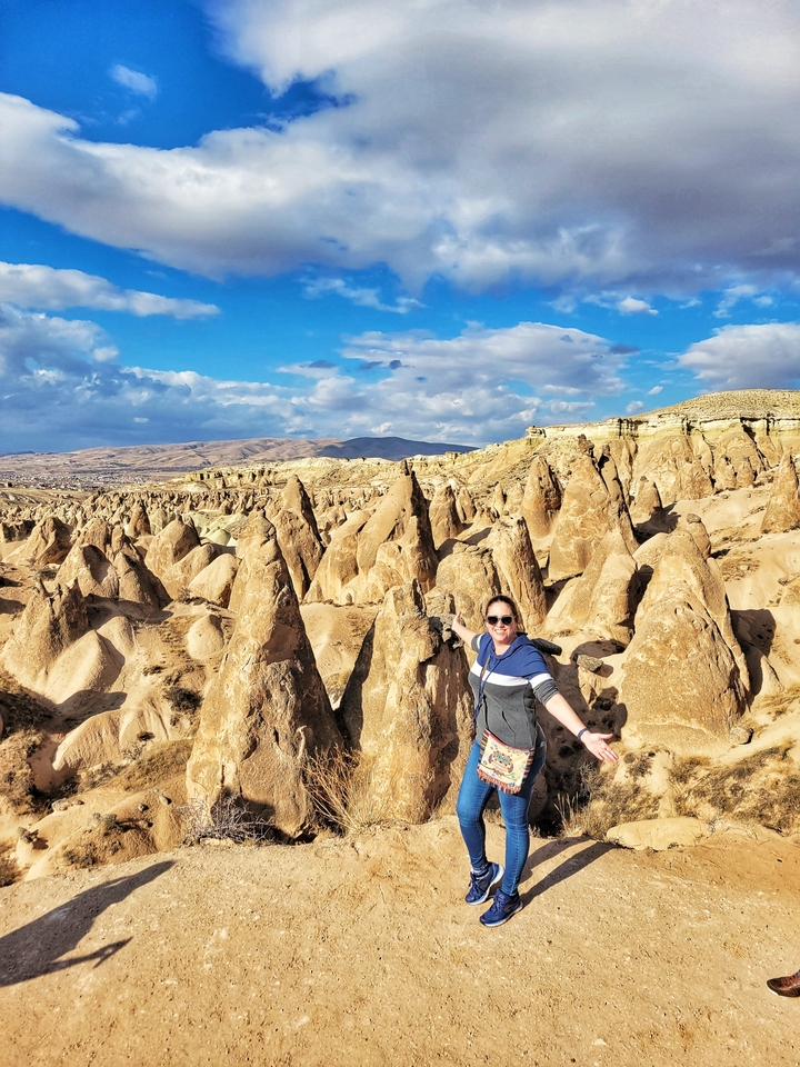 Person posing among unique rock formations.