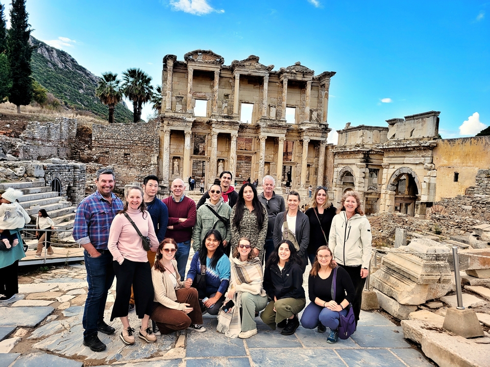 Group of people posing in front of ancient ruins.