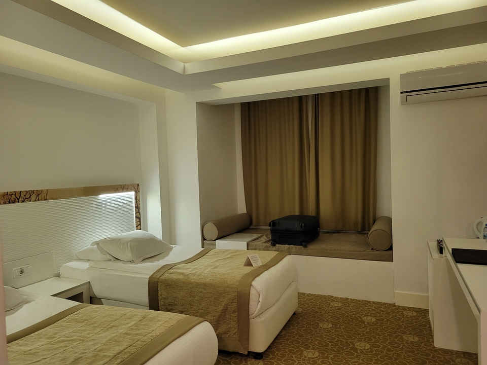Hotel room with twin beds and muted decor.