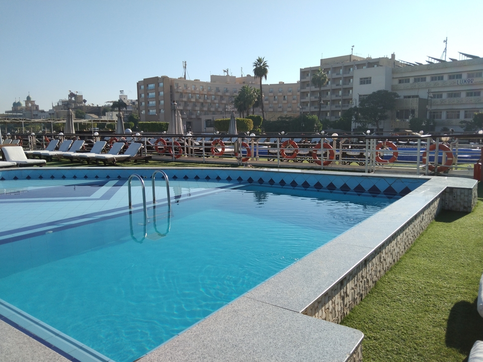 Hotel pool area with buildings in the background.