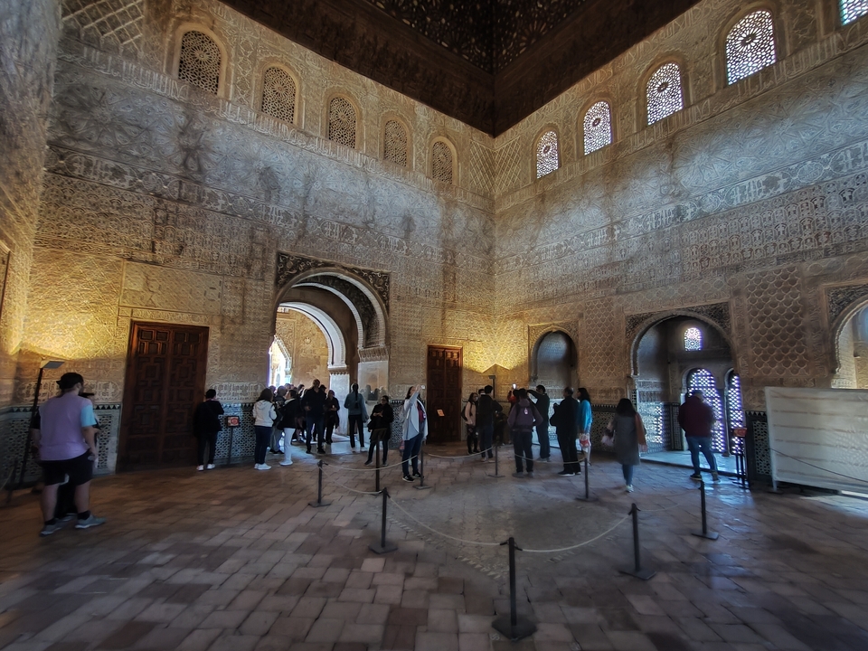 Vue intérieure d'une pièce ornée avec des personnes qui observent.