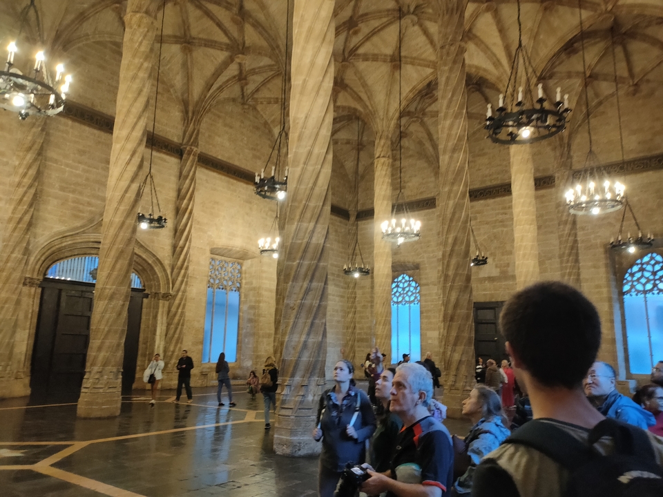 Intérieur d'une grande salle avec des piliers et des lustres.