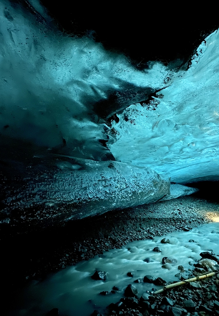 Vue intérieure d'une grotte de glace aux teintes bleues.