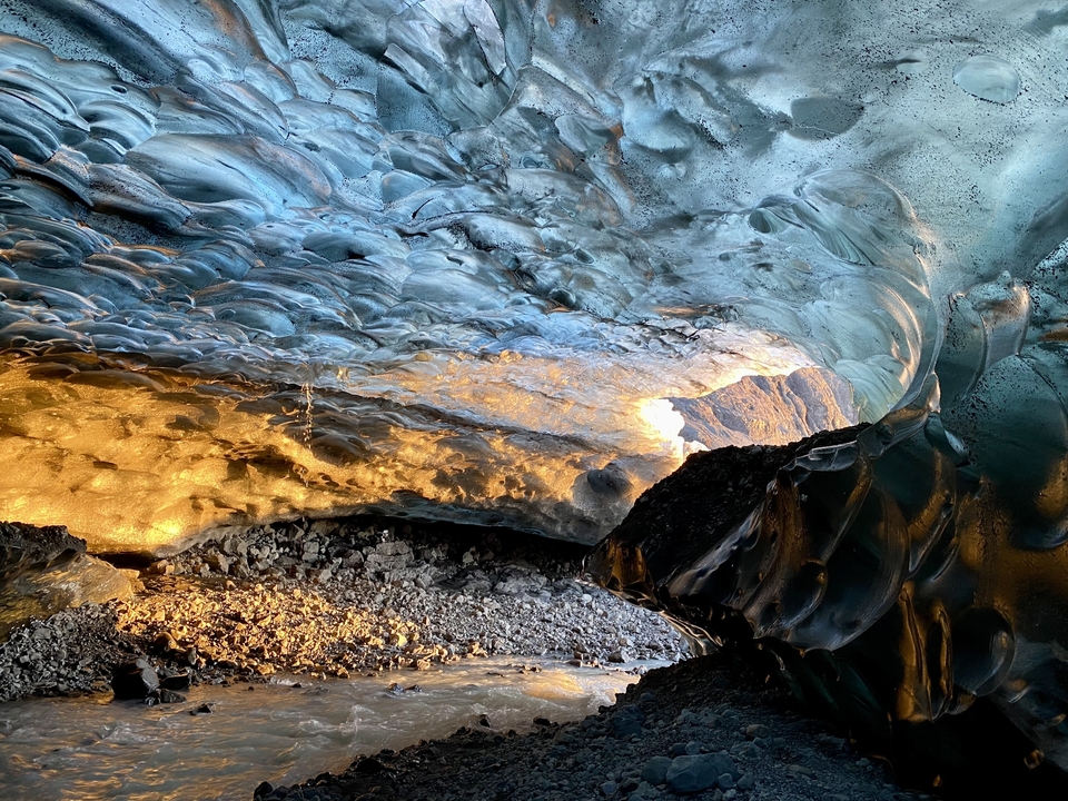 Intérieur de grotte de glace vibrant avec des tons chauds et froids.