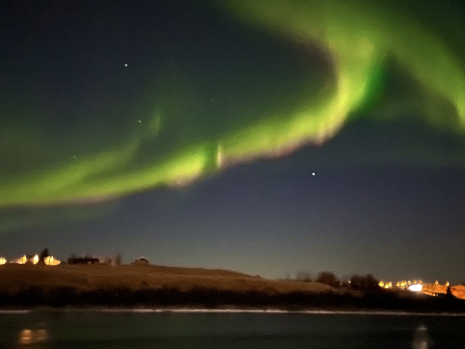 Blurry image of the northern lights in the night sky.