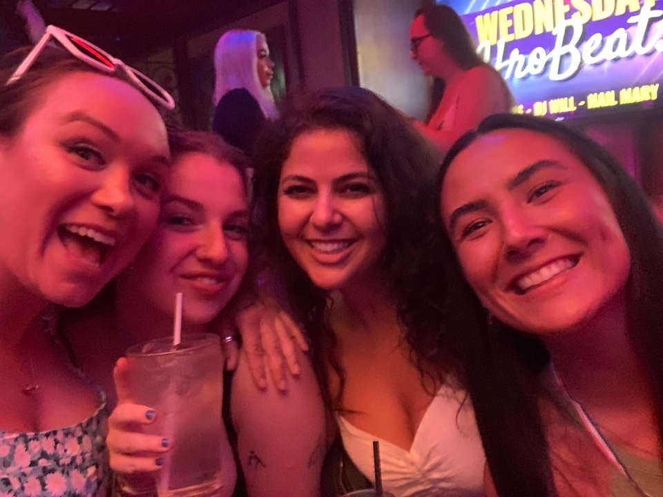 Group of friends smiling and taking a selfie in a nightclub.