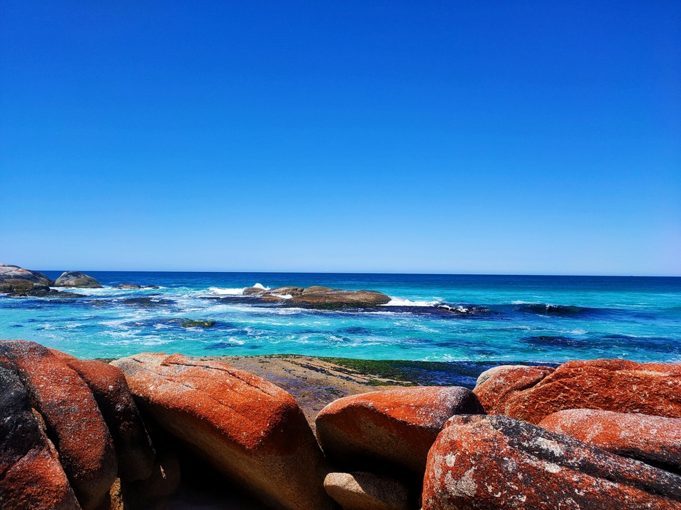 Bright blue ocean with rocky shoreline.