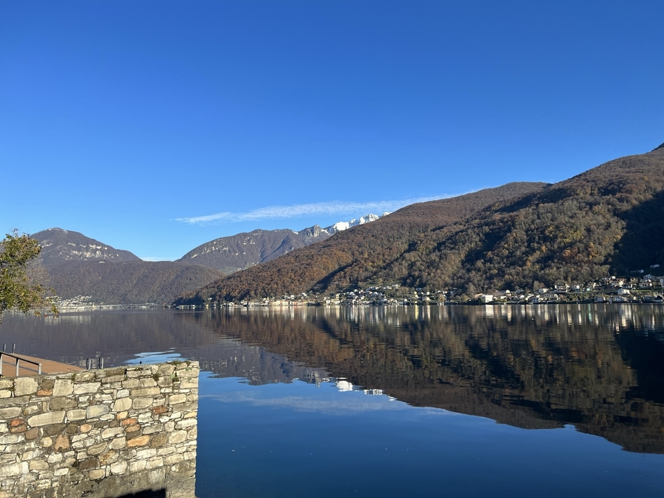 Vue sur le lac avec eaux réfléchissantes et montagnes.