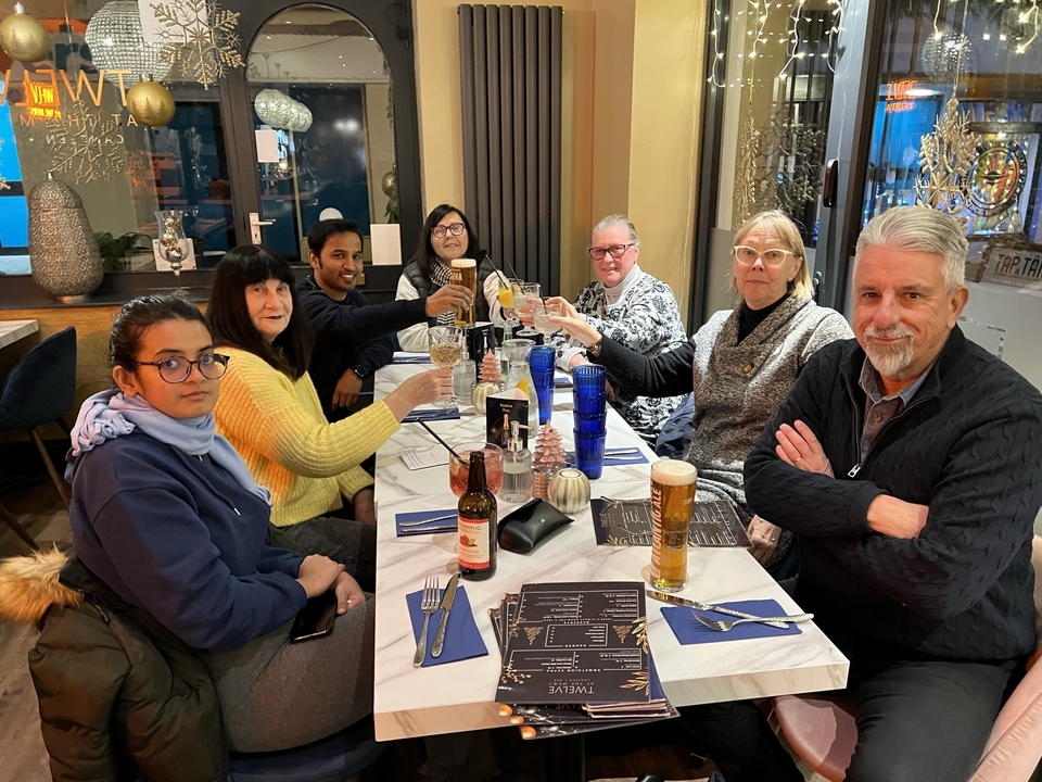 Group of people enjoying drinks at a dinner table.