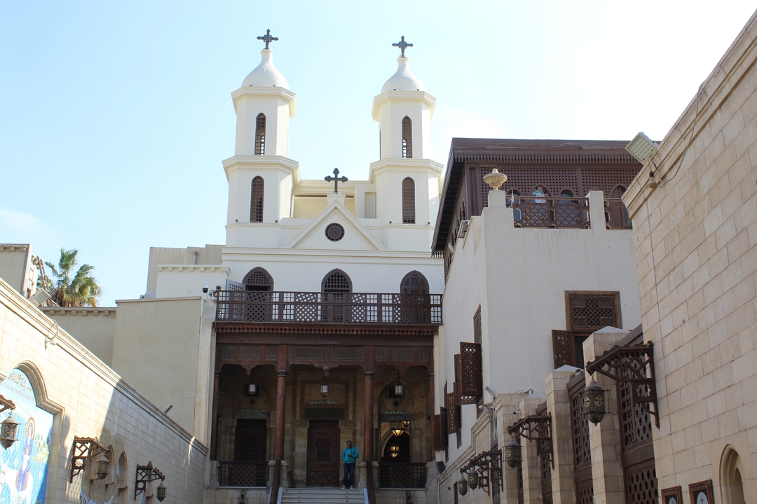 White religious building with twin towers in a city.