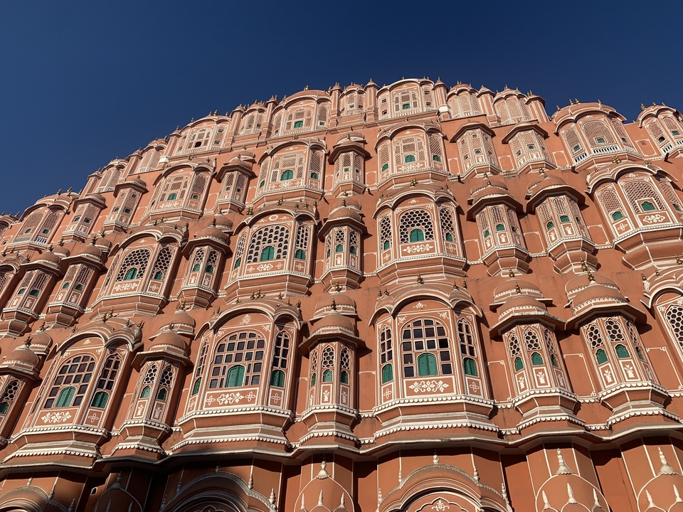 Facade of a pink historical building with many windows.