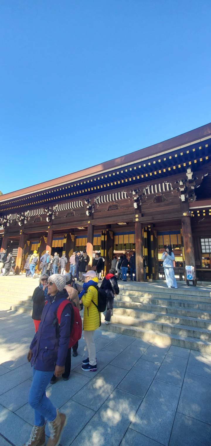 People gathered at a cultural site with traditional architecture.