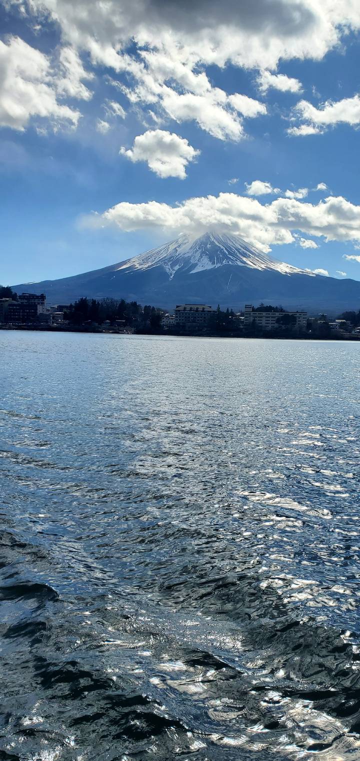 Mount Fuji across a large body of water on a sunny day.